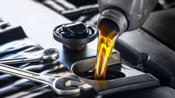 Golden industrial oil being poured into mechanical equipment